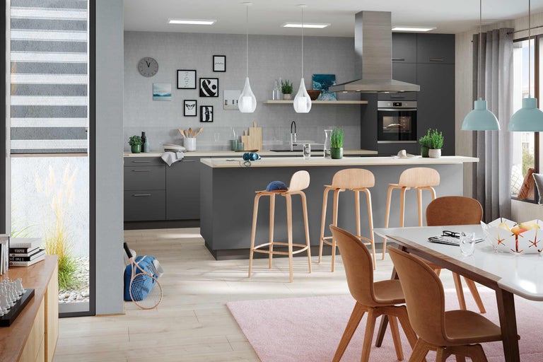 Cuisine lumineuse et spacieuse avec îlot de cuisson, tabourets de bar et coin repas