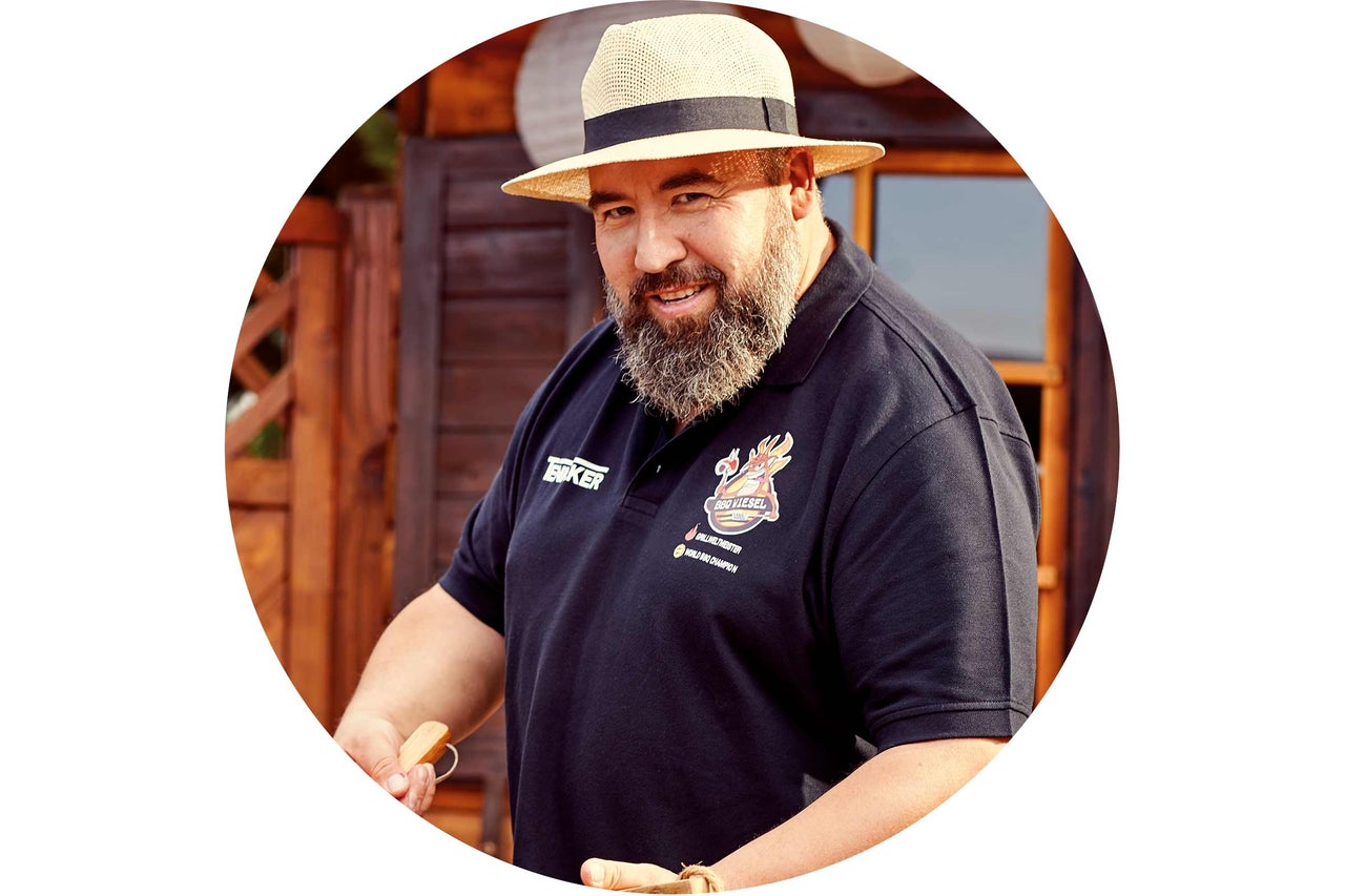 Homme barbu coiffé d’un chapeau remuant des aliments grillés