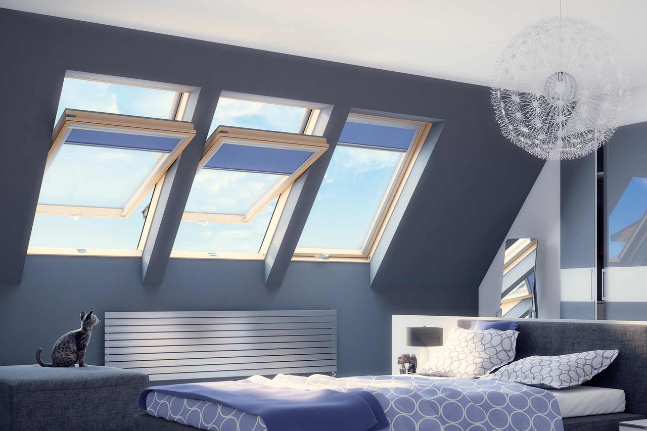 Helles Schlafzimmer mit Dachfenstern, Heizkörper und dekorativer Lampe
