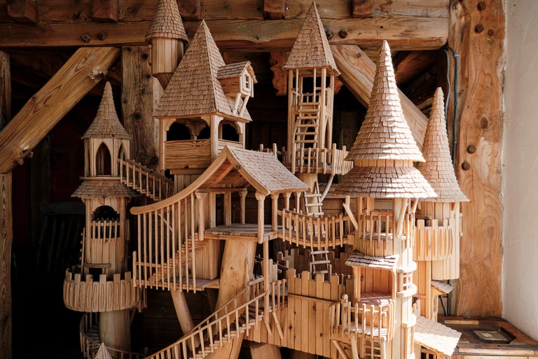 Detailaufnahme eines aufwendigen Holzbaumhausmodells mit Türmen, Treppen und Dächern mit Schindeln.