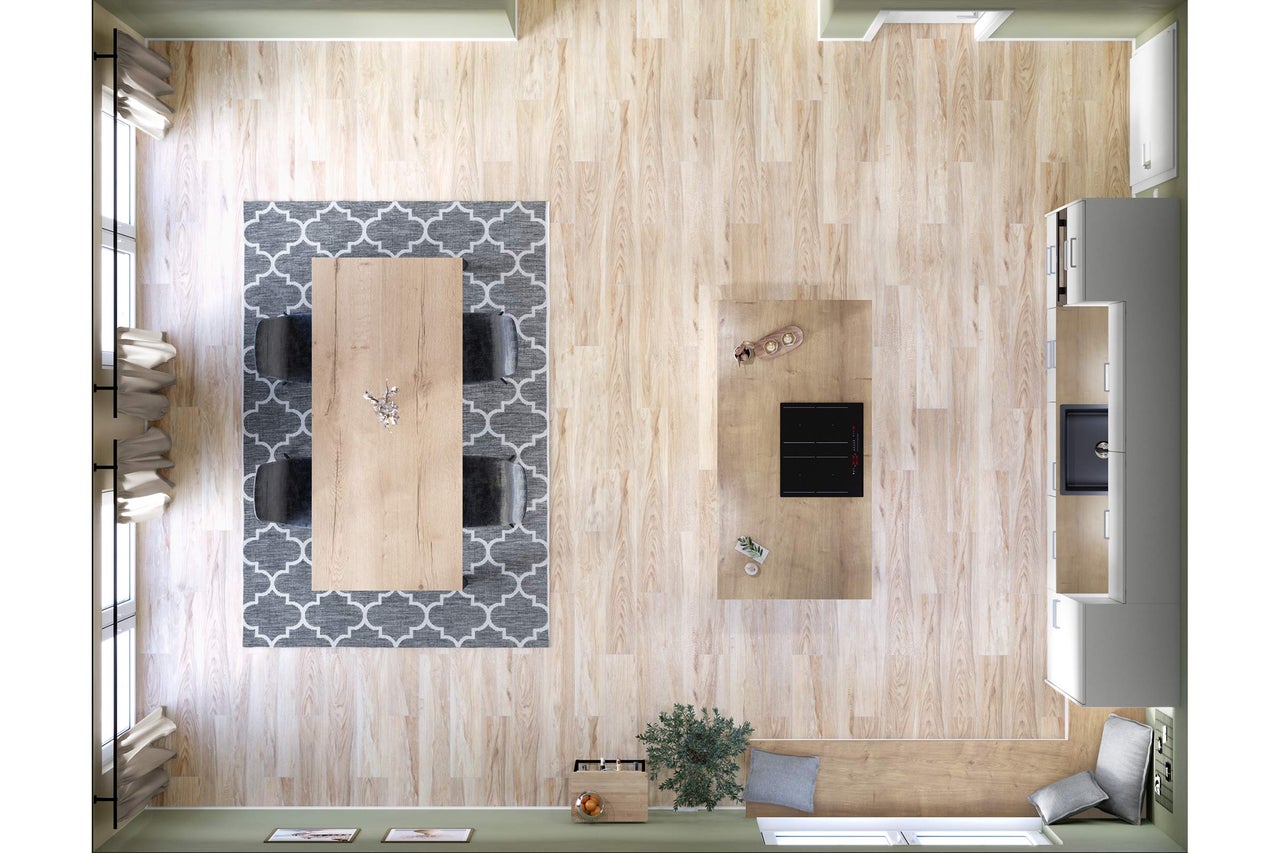 Vue plongeante sur un espace de vie lumineux avec parquet, table à manger sur un tapis à motifs et kitchenette.