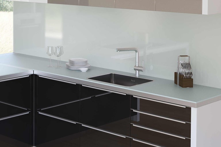 Cuisine moderne avec évier, robinet et ustensiles de cuisine sur le plan de travail.