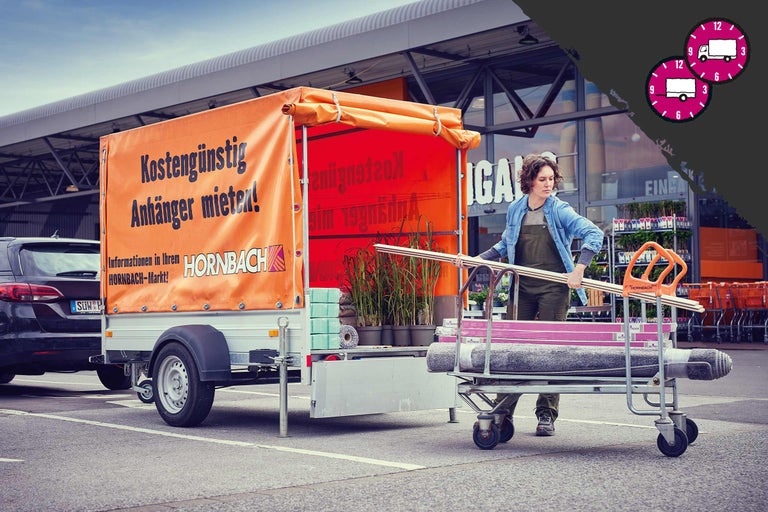 Scène avec une personne apportant un chariot de transport chargé d'articles de Hornbach à une remorque qui fait la promotion de la location de remorques à bas prix