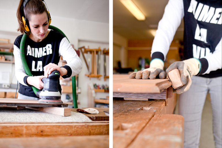 Frau schleift Holz mit einem Exzenterschleifer und Schleifpapier in einer Werkstatt.