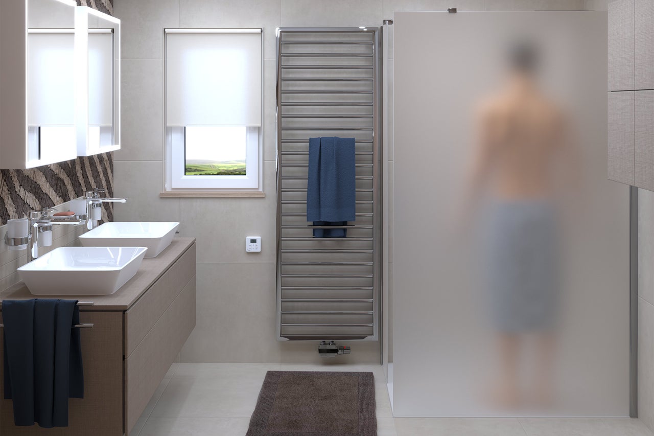 Salle de bains lumineuse avec double vasque, sèche-serviettes et cabine de douche