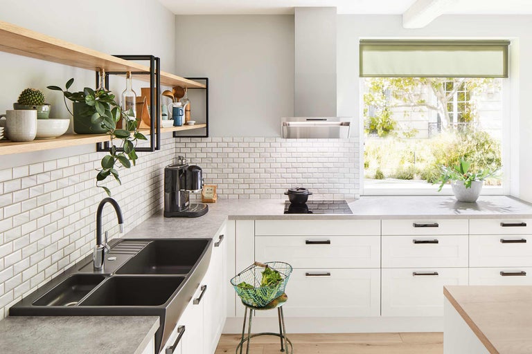Cuisine claire avec évier, plaque de cuisson, hotte aspirante, carrelage et étagères