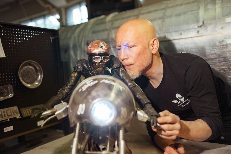 Mann mit Totenkopf Figur auf einem Motorrad