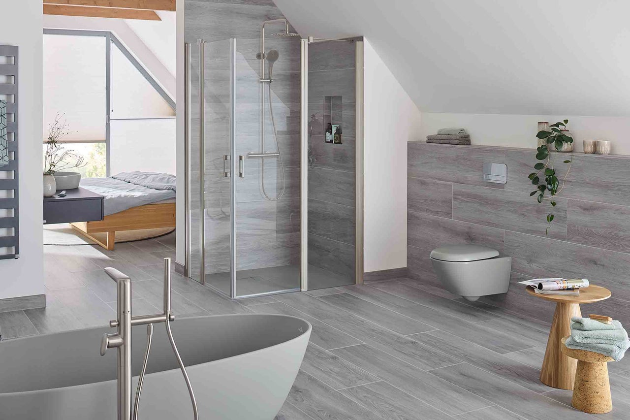 Salle de bain moderne avec douche, baignoire, toilettes et plancher en bois