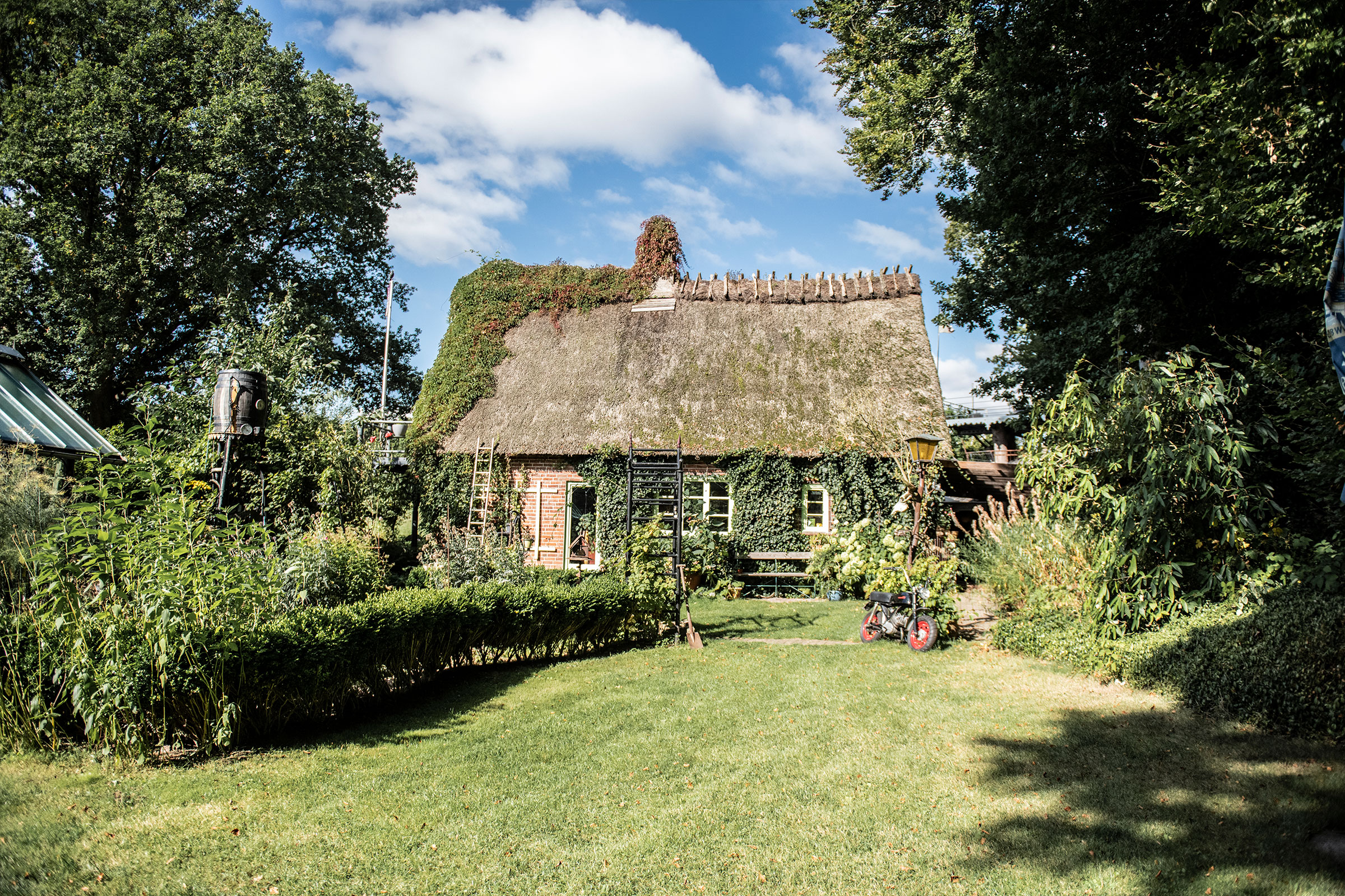 Haus mit Strohdach und Gartenanlage