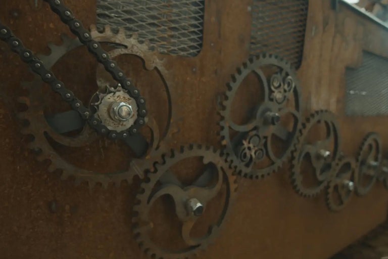 Gros plan d'engrenages métalliques avec chaîne sur une surface en bois