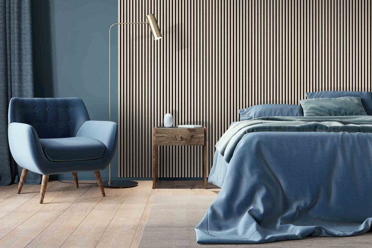 Chambre avec lit, fauteuil, lampadaire et mur en panneaux de bois