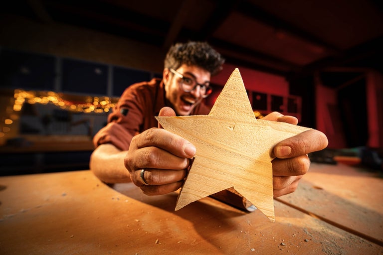 Un homme tient une étoile en bois à la main