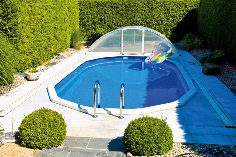 Piscine avec abri de piscine et échelle dans le jardin