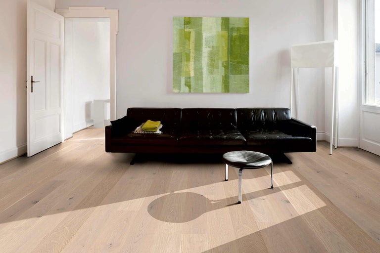 Plancher en bois clair dans un salon avec canapé et œuvre d'art