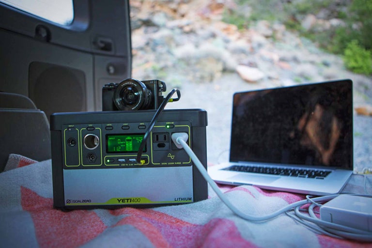 Goal Zero Logo. Tragbare Yeti 400 Lithium Powerstation mit Laptop und Kamera im Kofferraum.