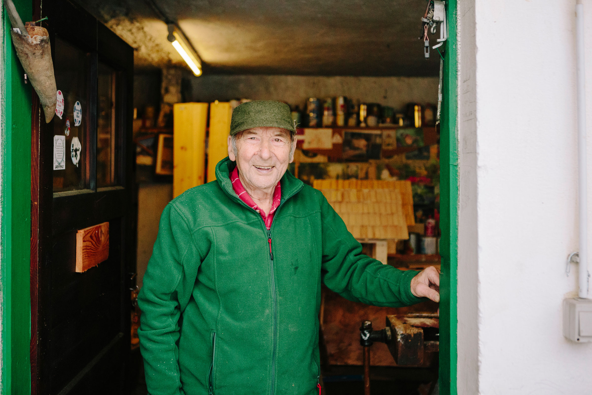Ein Mann mit Mütze und Fleecejacke steht in der Tür einer Werkstatt.