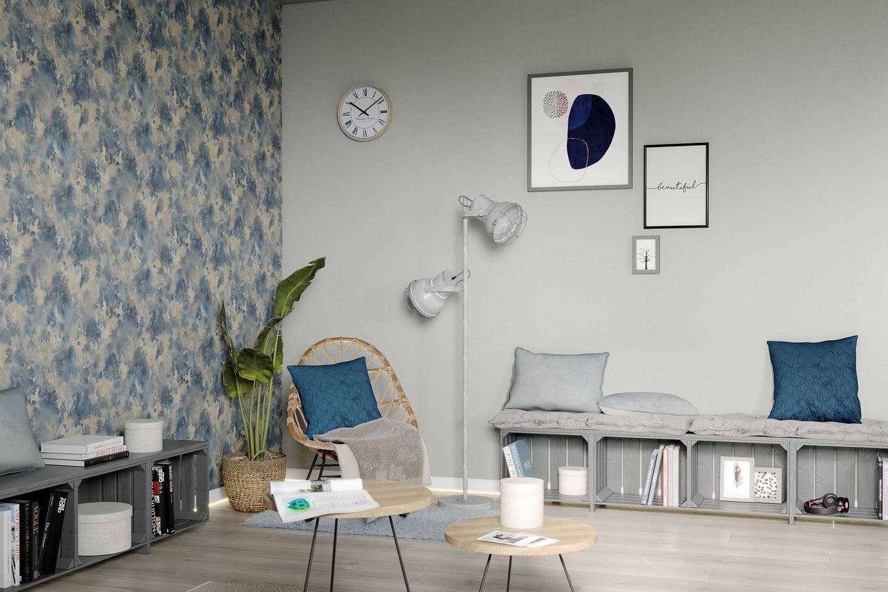 Salon avec fauteuil en rotin, lampadaire, table basse et peintures murales