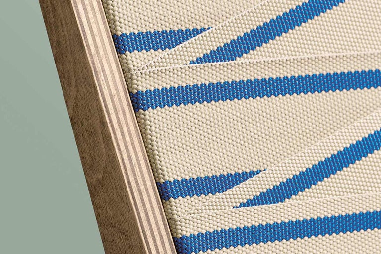 Detailansicht eines Stuhls mit blau gestreifter Stoffbespannung und Holzrahmen