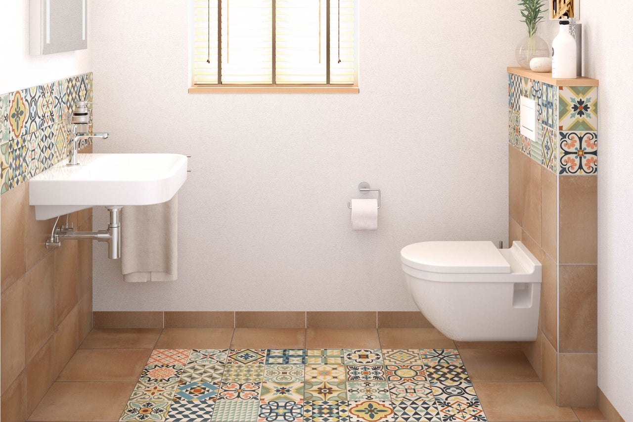 Salle de bain lumineuse avec lavabo, toilettes et carrelage mosaïque