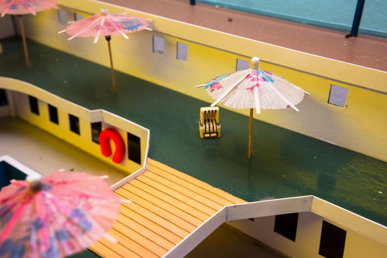 Modell eines Schiffdecks mit Sonnenschirmen, Liegestuhl und Rettungsring