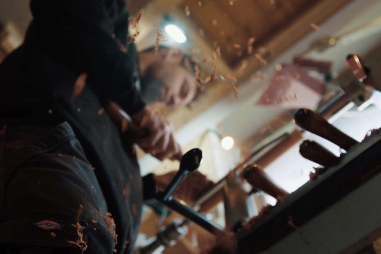 Mann drechselt Holz mit Drechselmaschine