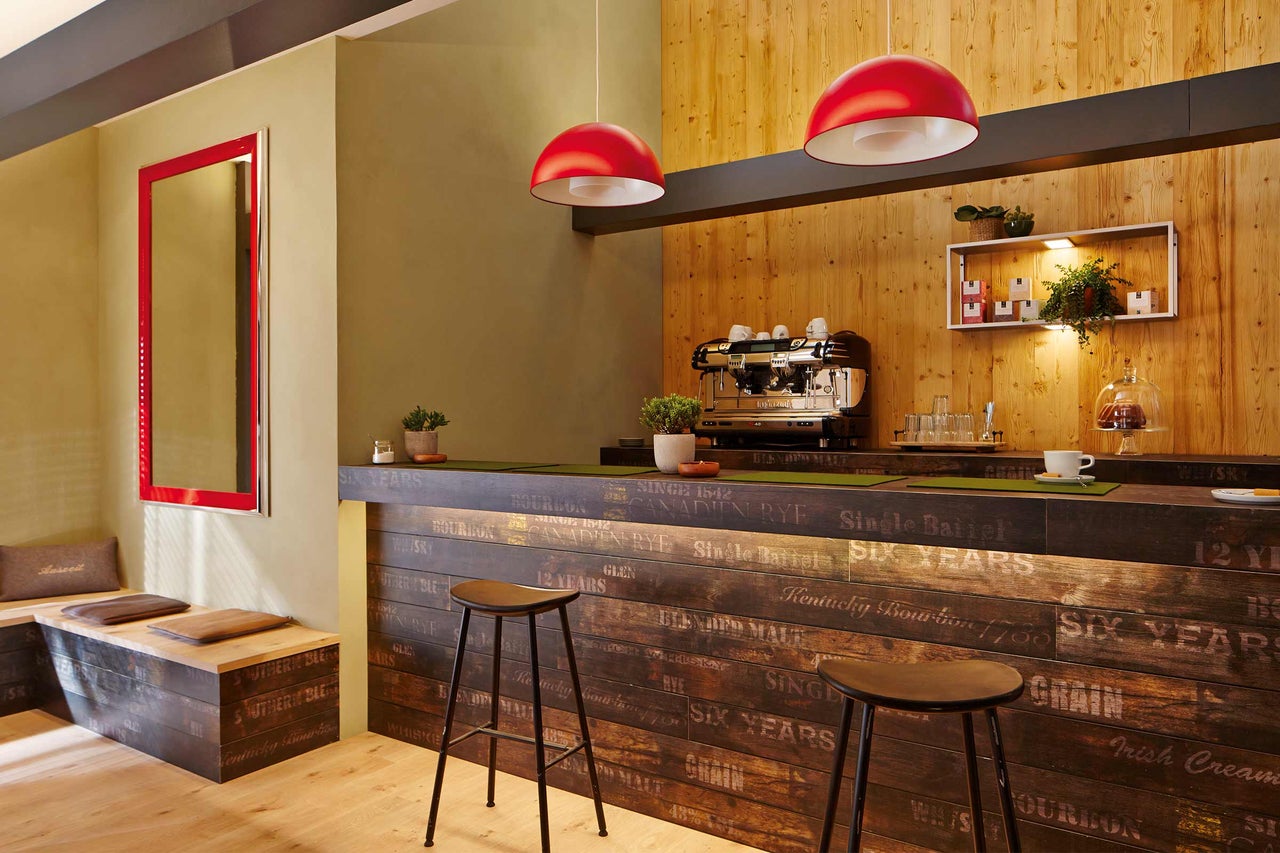 Intérieur avec des éléments en bois, machine à café et sièges