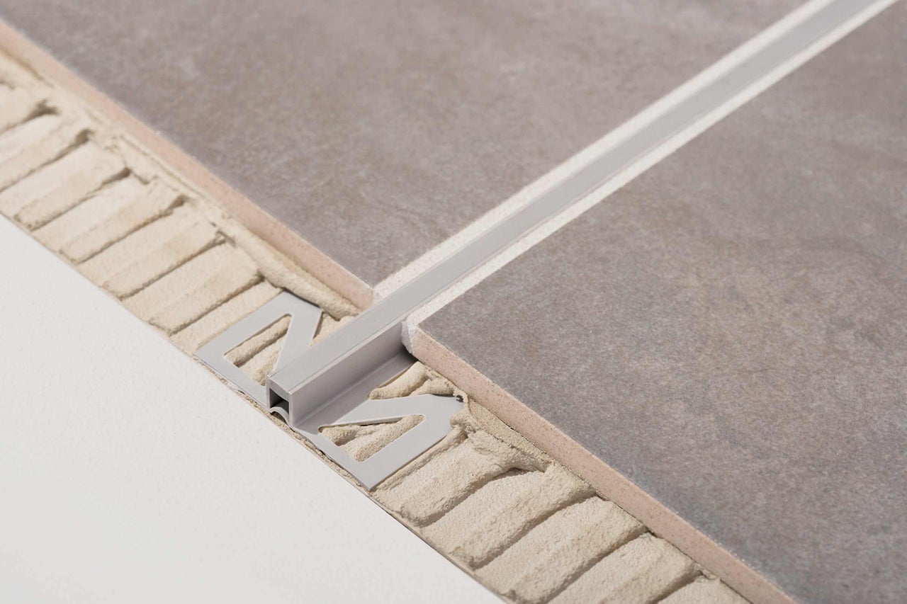 Vue détaillée d'un profilé de carreaux métallique entre deux carreaux