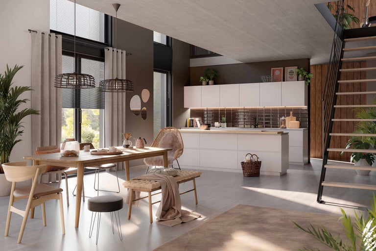 Espace de vie lumineux avec coin repas, cuisine et escalier menant à l'étage supérieur. La pièce est aménagée de manière claire et conviviale.