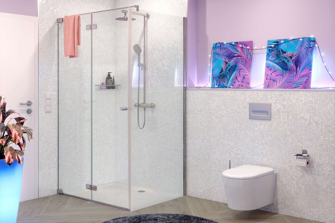 Salle de bains moderne avec cabine de douche en verre, douche de tête, WC suspendu et mosaïque claire.