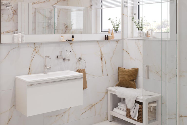 Salle de bains lumineuse avec lavabo, miroir, porte-serviettes et banc devant un mur en marbre
