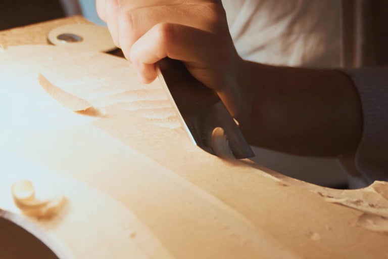 Handwerker bearbeitet Holz mit Stecheisen