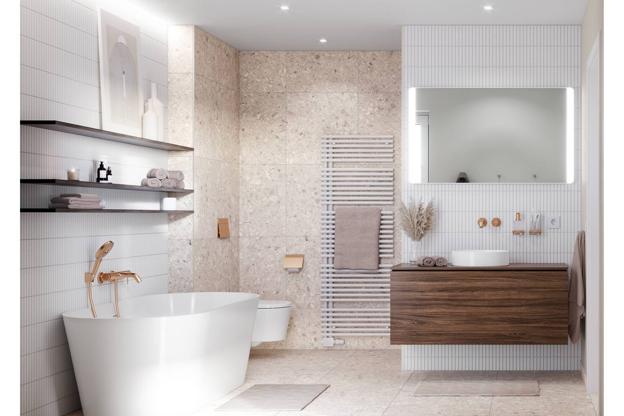 Salle de bains moderne avec baignoire îlot, robinetterie dorée, meuble sous-vasque en bois, vasque à poser et carrelage clair aspect pierre.