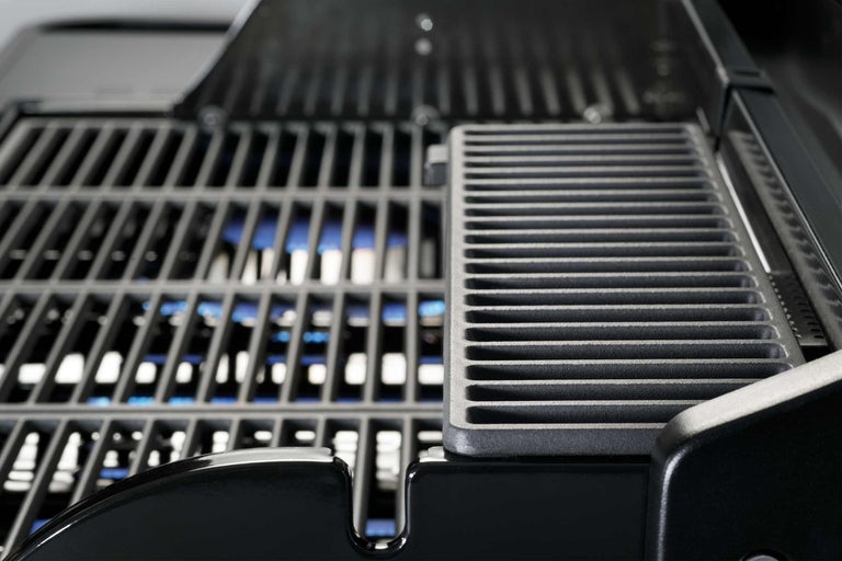 Gros plan d'un gril à gaz avec grille et brûleurs