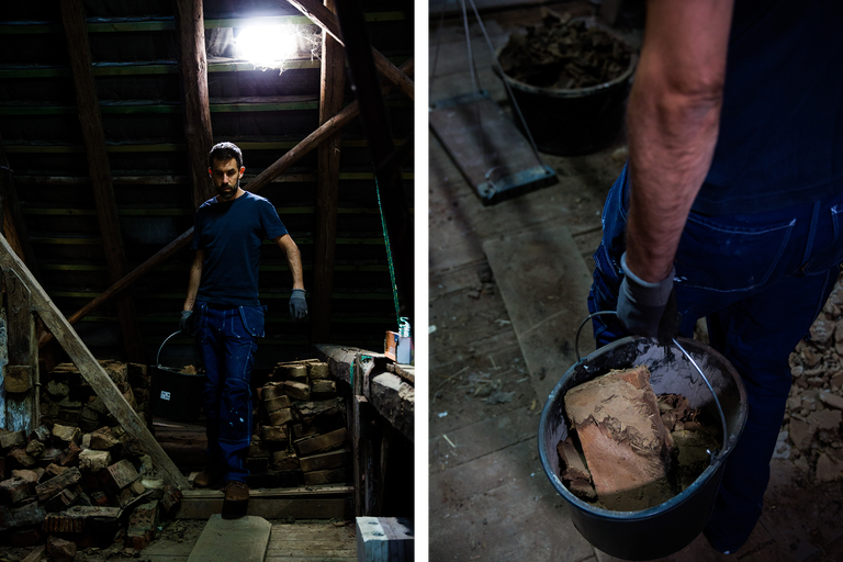 Mann mat Eemer voller Steng op engem Dachgeschoss.