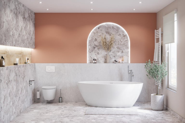 Salle de bains moderne avec baignoire îlot, toilettes et éléments décoratifs.