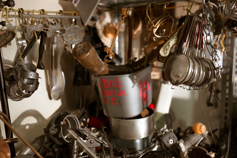 Gros plan de divers outils et objets métalliques suspendus et rangés dans un atelier.