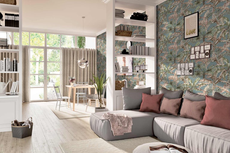 Heller Wohnraum mit Sofa, Regal, Esstisch und tropischer Tapete