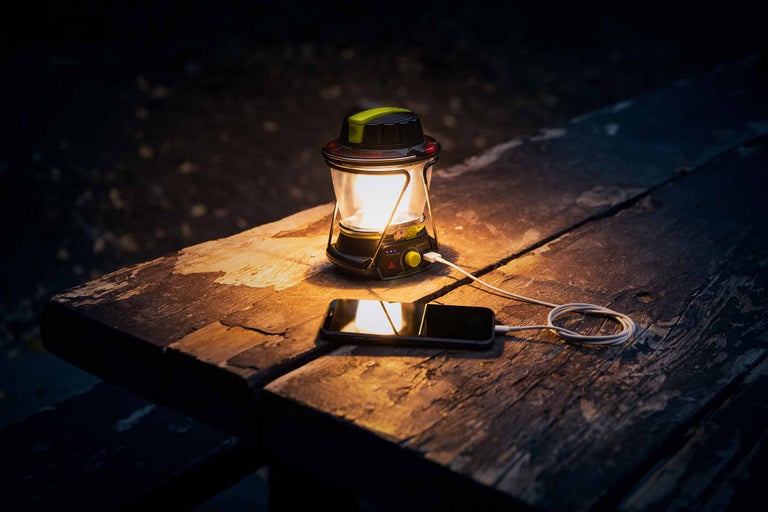 Laterne lädt ein Mobiltelefon auf einem Holztisch auf