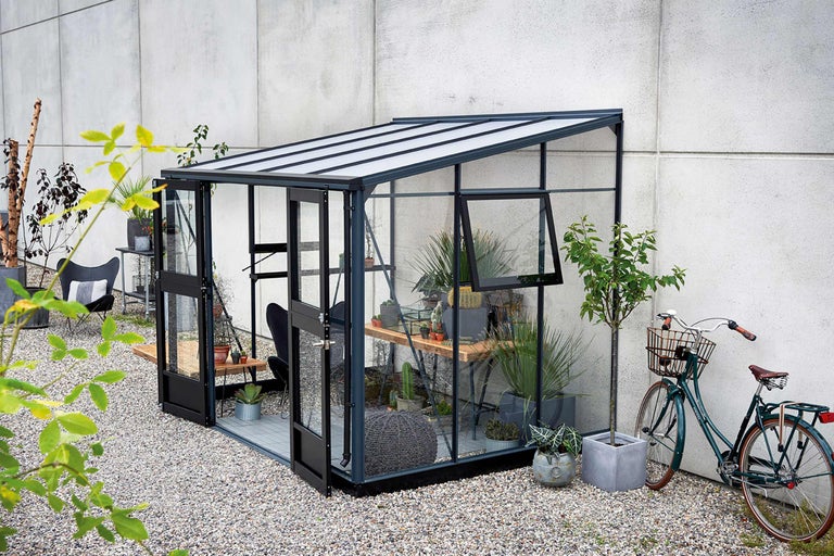 Serre avec plantes et décoration de jardin en extérieur.