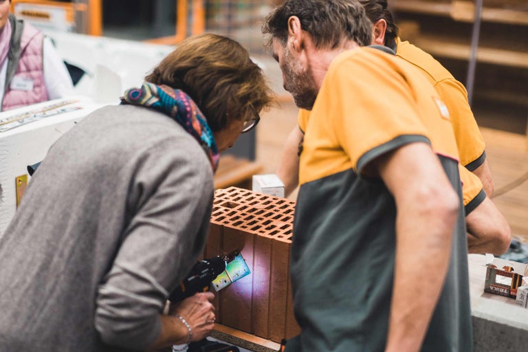 Personnes fixant une fixation sur une brique avec un outil