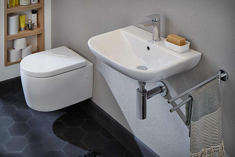 Salle de bain avec WC suspendu, lavabo, porte-serviettes et étagère