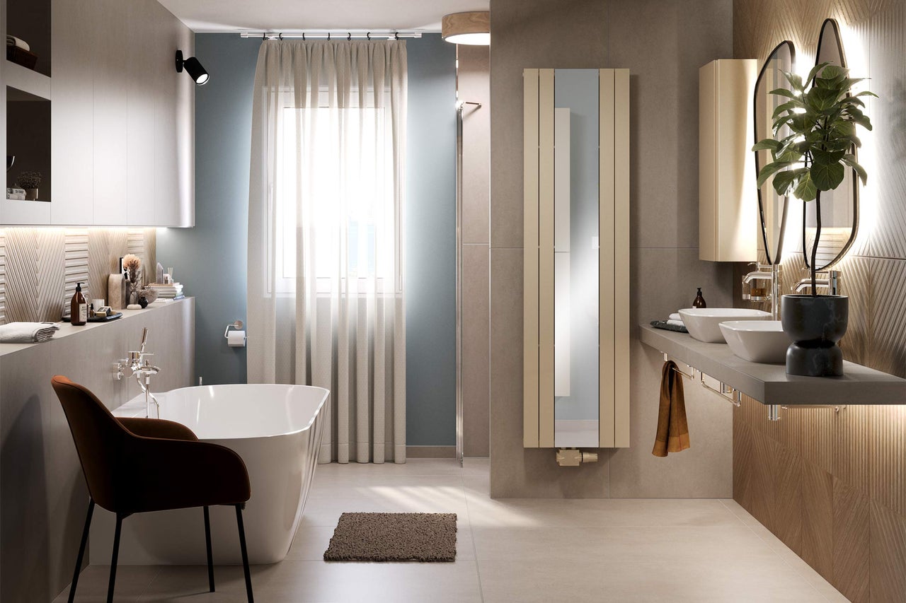 Salle de bain lumineuse avec baignoire, meuble-lavabo avec deux vasques, radiateur et chaise