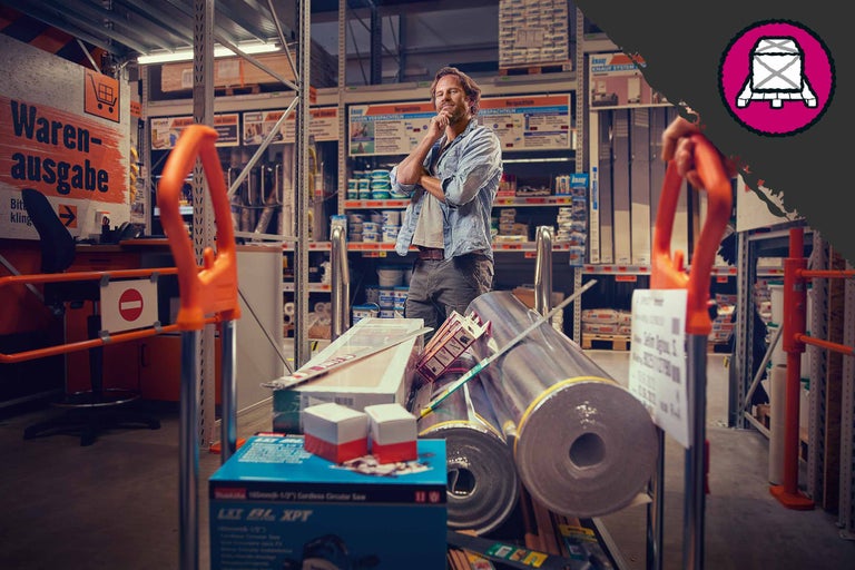 Client avec un chariot dans une quincaillerie avec des matériaux de construction, des outils et des matériaux isolants
