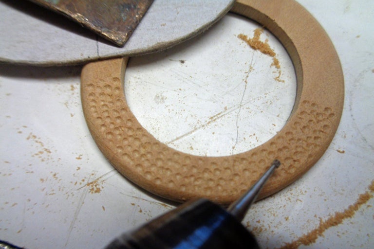 Un anneau en bois est travaillé avec un outil de fraisage.