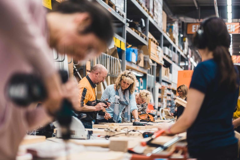 Des personnes travaillent avec des outils électriques sur un établi dans un magasin Hornbach.