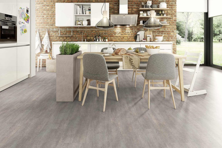 Cuisine moderne et lumineuse avec table à manger et chaises devant un mur en briques