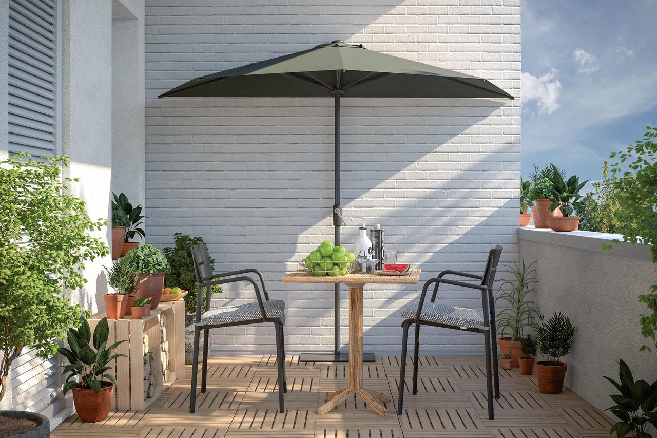 Balcon avec parasol, table et chaises sur plancher en bois