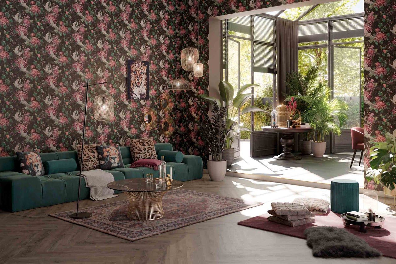 Salon avec papier peint à motifs, canapé, table basse et plantes pour une ambiance vivante