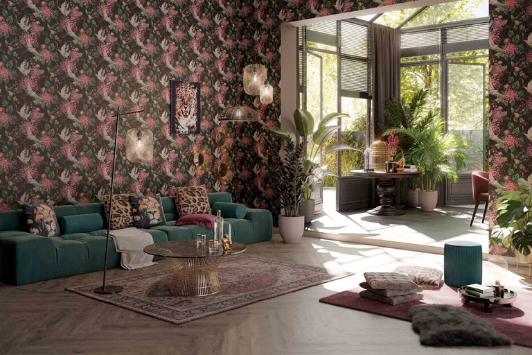 Salon avec papier peint à motifs, canapé, table basse et plantes pour une ambiance vivante