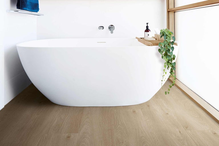 Salle de bain moderne avec baignoire îlot, plancher en bois et design minimaliste.